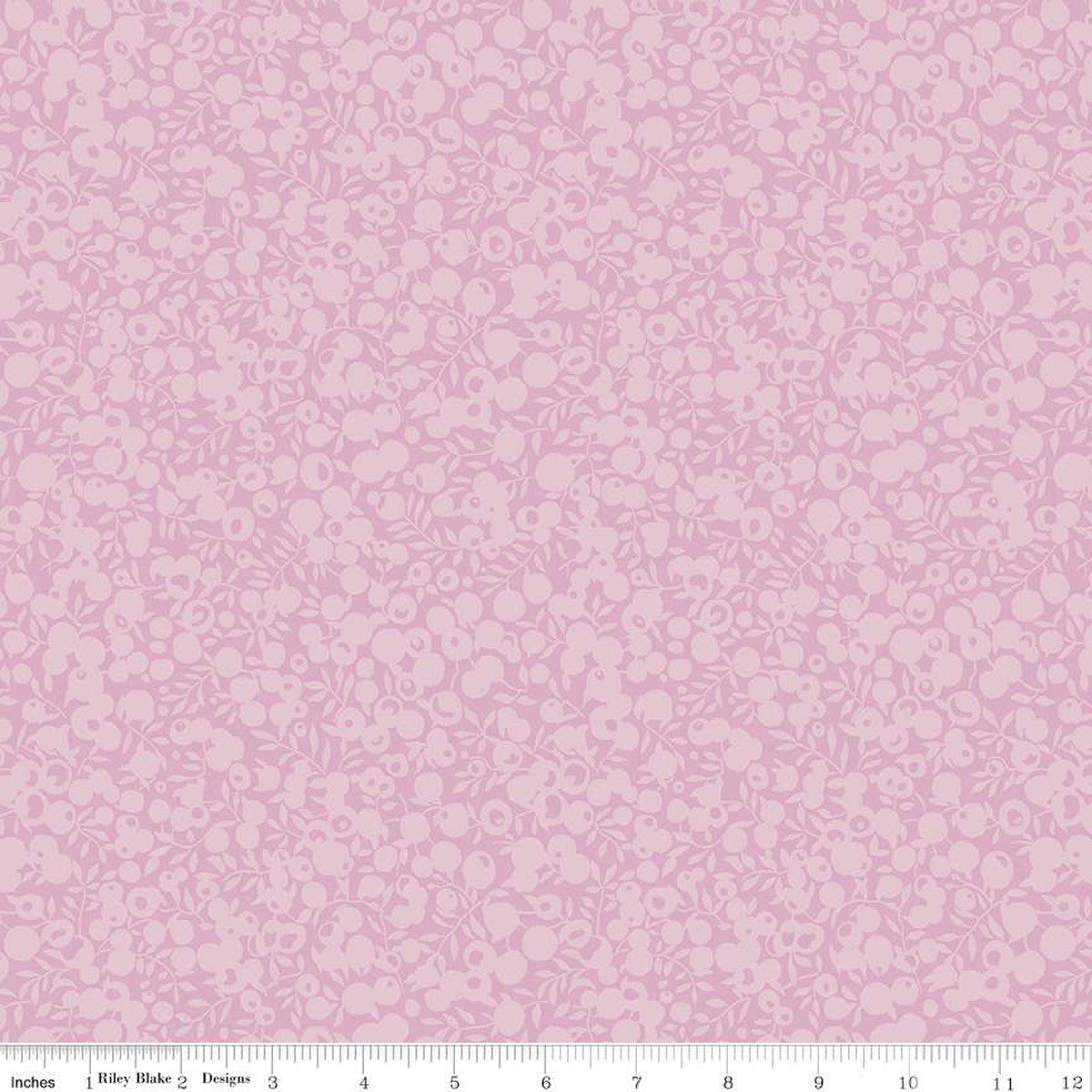 A close-up of a pink fabric pattern with a repeating small floral or cherry-like motif, plus a ruler strip along the bottom edge showing measurements.
Photo by RileyBlakeDesigns.com [image_link]