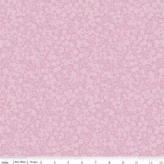 A close-up of a pink fabric pattern with a repeating small floral or cherry-like motif, plus a ruler strip along the bottom edge showing measurements.
Photo by RileyBlakeDesigns.com [image_link]