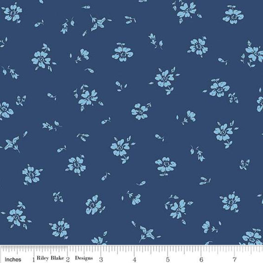 A fabric pattern swatch featuring a repeating light blue floral print on a dark navy blue background, with a white ruler at the bottom showing inch measurements.
Photo by RileyBlakeDesigns.com [image_link]