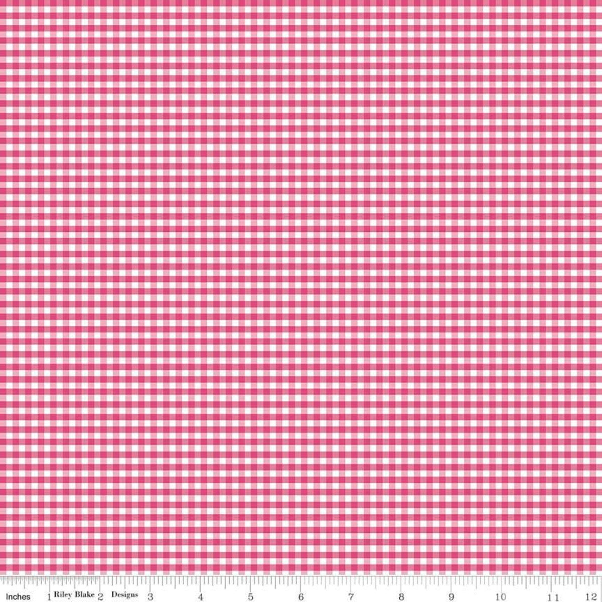 A close-up of a pink and white gingham checkered fabric pattern with a measuring ruler along the bottom edge showing inches and centimeters.
Photo by Riley Blake [additional_image_link]
