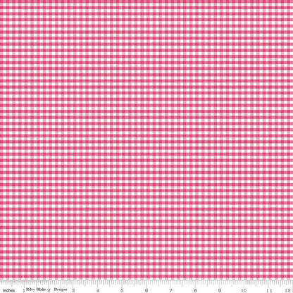 A close-up of a pink and white gingham checkered fabric pattern with a measuring ruler along the bottom edge showing inches and centimeters.
Photo by Riley Blake [additional_image_link]