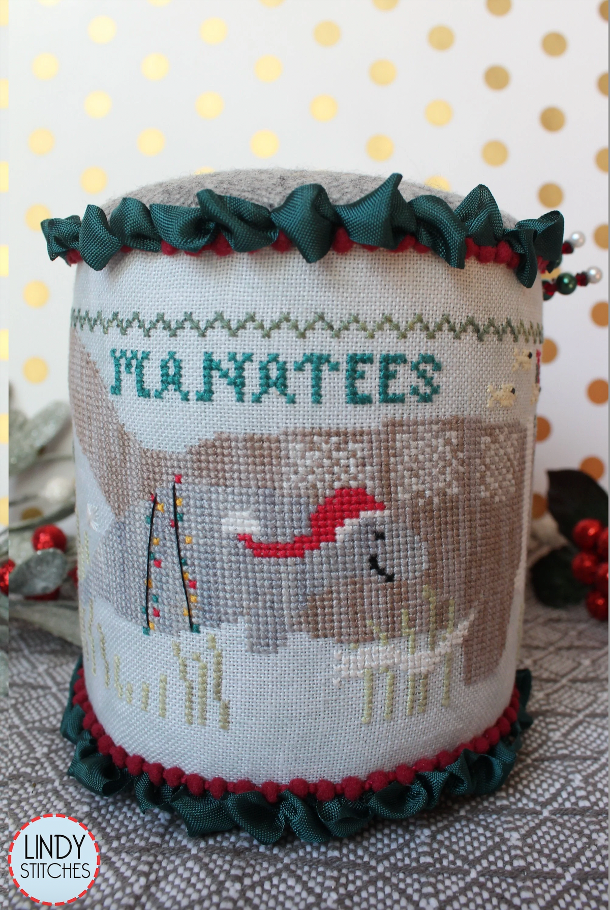 A cross stitch pattern drum kit depicting manatees in a Christmas theme, with holiday decorations and a Santa hat, from Lindy Stitches.
Photo by Lindy Stitches [additional_image_link]