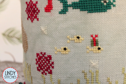 A cross stitch pattern drum kit depicting manatees in a Christmas theme, with holiday decorations and a Santa hat, from Lindy Stitches. Close up.
Photo by Lindy Stitches [additional_image_link]