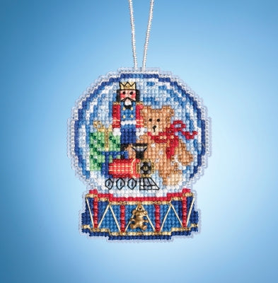 A cross-stitch embroidery kit depicting a snow globe scene, featuring a king and a bear in a winter setting, completed with glass beads and a beaded hanger.
Photo by Mill Hill [image_link]