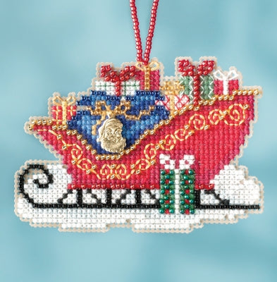 A traditional sleigh-shaped cross stitch embroidery kit depicting a sleigh with glass beaded ornaments, charms, and the text 'Sleigh Ride'.
Photo by Mill Hill [image_link]