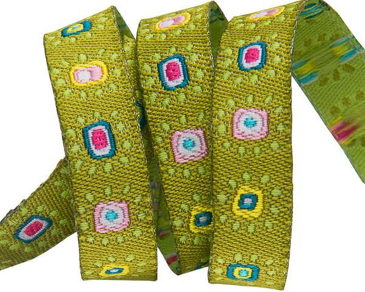 A spool of green jacquard ribbon featuring a pattern of mini suns and geometric shapes in bright colors.
Photo by renaissanceribbon.com [image_link]