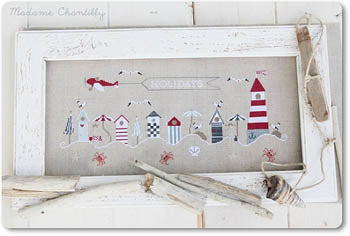 A cross stitch kit depicting a beach scene with various elements like beach houses, lighthouse, starfish, and crabs on a white background.
Photo by madamechantilly.com [image_link]
