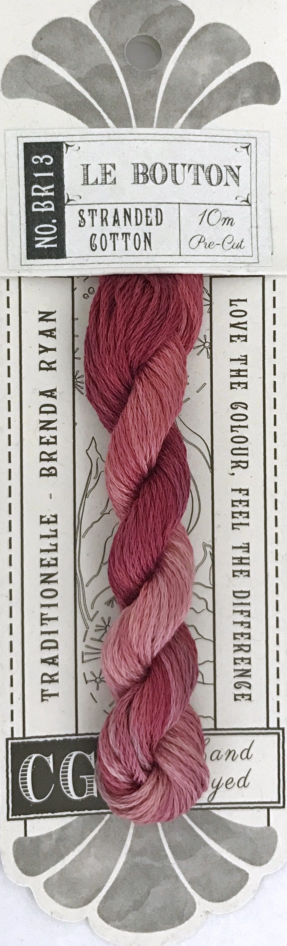 A packaged skein of Le Bouton stranded cotton yarn by Brenda Ryan, featuring a pink and mauve gradient from light to dark, on a white card with gray decorative elements.
Photo by cottagegardenthread.com [additional_image_link]