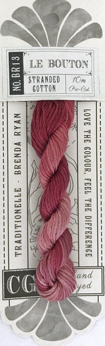 A packaged skein of Le Bouton stranded cotton yarn by Brenda Ryan, featuring a pink and mauve gradient from light to dark, on a white card with gray decorative elements.
Photo by cottagegardenthread.com [additional_image_link]