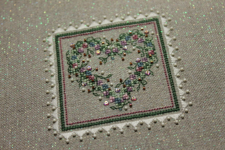A cross stitch embroidery kit packaging from The Sweetheart Tree featuring a heart-shaped design with floral patterns.
Photo by The Sweetheart Tree [additional_image_link]