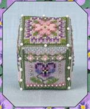 A small decorative cross-stitch cube with floral patterns in pink, purple, and green, set against a light blue background with an octagonal border.
Photo by JustNan.com [additional_image_link]