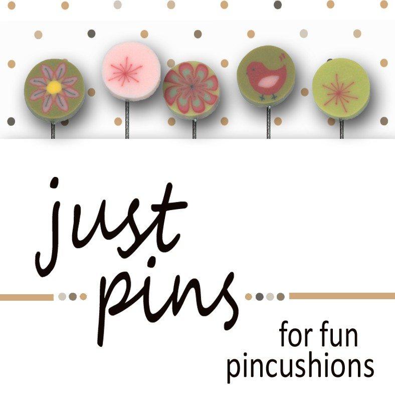A product display for 'just pins for fun pincushions' featuring five decorative circular pins on metal stands against a white background with gold polka dots. The pins include floral, geometric, and bird designs in muted green, pink, and yellow tones.
Photo by JustAnotherButtonCompany.com [image_link]