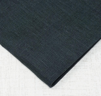 A close-up of folded dark charcoal gray fabric with a textured weave, placed on a light gray surface.
Photo by Wichelt.com [additional_image_link]
