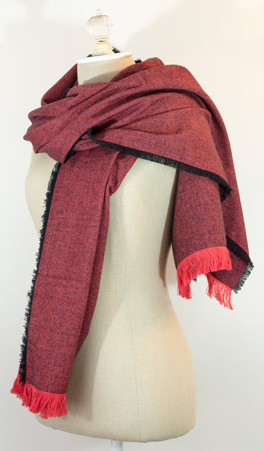 A red and black herringbone flannel blanket scarf displayed on a mannequin, with a kilt pin included.
Photo by Karen King [image_link]