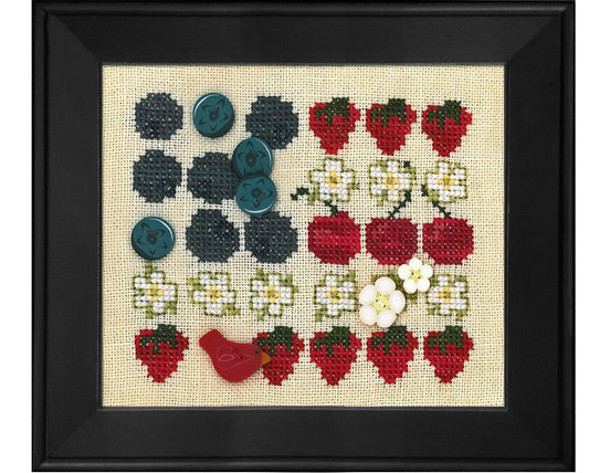 A framed cross-stitch sampler featuring rows of embroidered strawberries, blueberries, white flowers, and a small red bird on a beige fabric background, enclosed in a black frame.
Photo by JustAnotherButtonCompany.com [image_link]