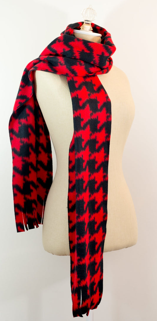 A scarf with a geometric houndstooth pattern in shades of red and black, displayed on a mannequin.
Photo by Karen King [image_link]