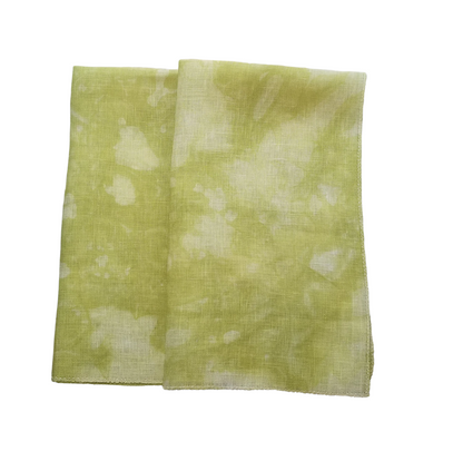 A folded square  linen fabric, featuring a light olive green and white tie-dye pattern on a plain white background.
Photo by Fabrics by Stephanie [additional_image_link]