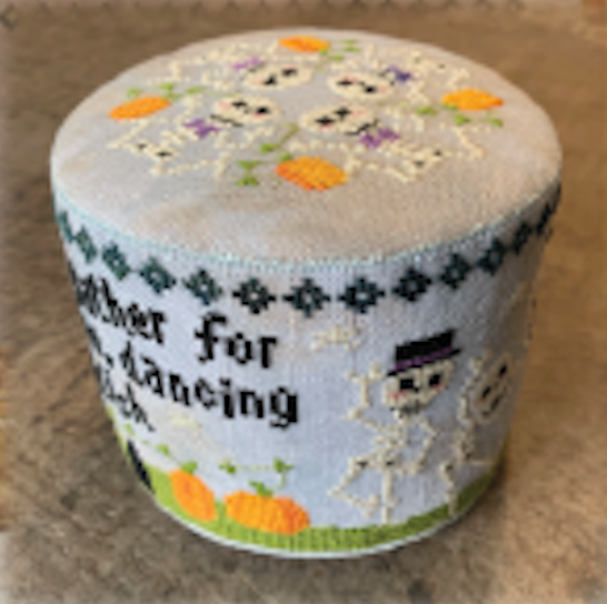 A round, cylindrical cross stitch canvas featuring a Halloween design with skeletons, pumpkins on a light blue background.
Photo by Tiny Modernist [image_link]