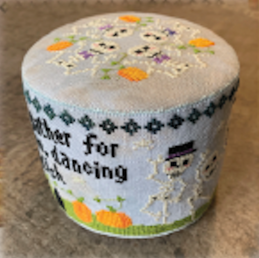 A round, cylindrical cross stitch canvas featuring a Halloween design with skeletons, pumpkins on a light blue background.
Photo by Tiny Modernist [image_link]