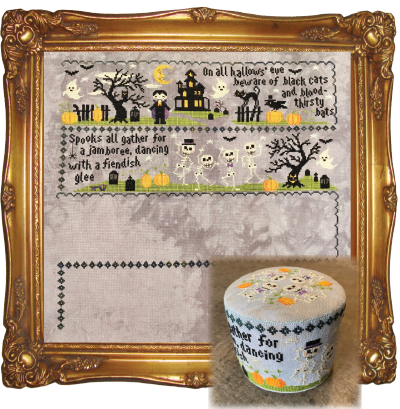 A framed Halloween-themed needlepoint canvas with a decorative gold frame, shown alongside a matching round storage box. The needlepoint design features a haunted house, tombstones, pumpkins, bats, and skeleton figures with embroidered text on a light gray background.
Photo by Tiny Modernist [additional_image_link]