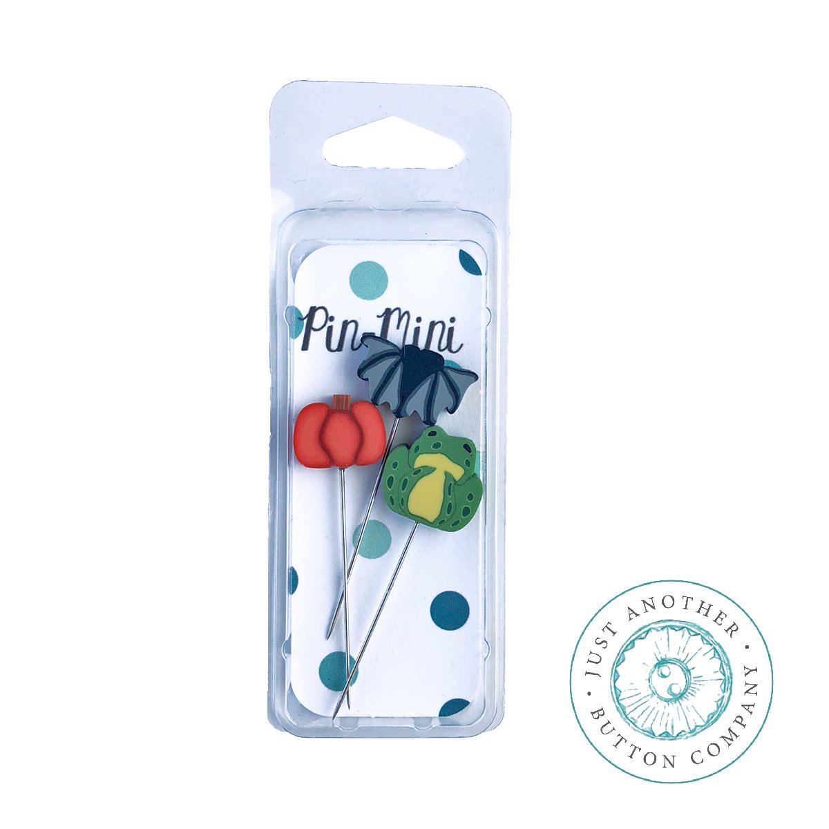 Three mini decorative pins in a clear plastic blister pack with a white backing card. The pins include a red flower, a dark blue flower, and a green leaf on metal wires.
Photo by JABC [additional_image_link]