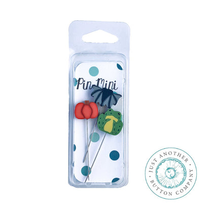 Three mini decorative pins in a clear plastic blister pack with a white backing card. The pins include a red flower, a dark blue flower, and a green leaf on metal wires.
Photo by JABC [additional_image_link]
