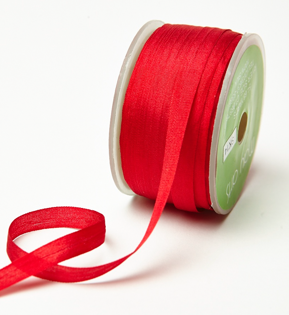 A spool of bright red ribbon with a length of the ribbon unspooled, set against a plain white background.
Photo by MayArts.com [additional_image_link]