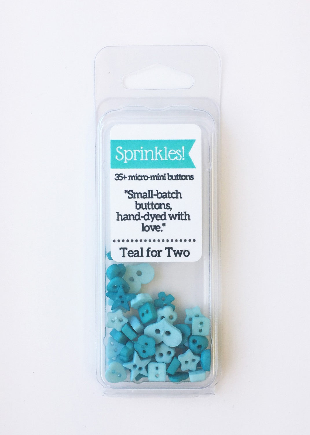 A pack of teal blue sprinkle buttons of various sizes, displayed in a clear plastic case with a label showing the brand and product details.
Photo by JustAnotherButtonCompany.com [image_link]