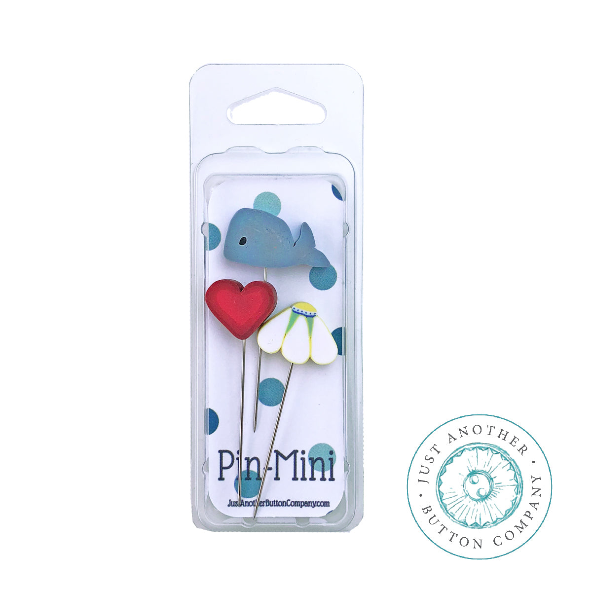 A set of three decorative metal pins in a clear plastic blister pack, featuring a blue whale, a red heart, and a white flower with green leaves. The packaging displays the brand name 'Pin-Mini' and a circular logo for 'Just Another Button Company'.
Photo by JABC.com [additional_image_link]