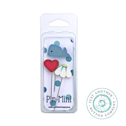 A set of three decorative metal pins in a clear plastic blister pack, featuring a blue whale, a red heart, and a white flower with green leaves. The packaging displays the brand name 'Pin-Mini' and a circular logo for 'Just Another Button Company'.
Photo by JABC.com [additional_image_link]