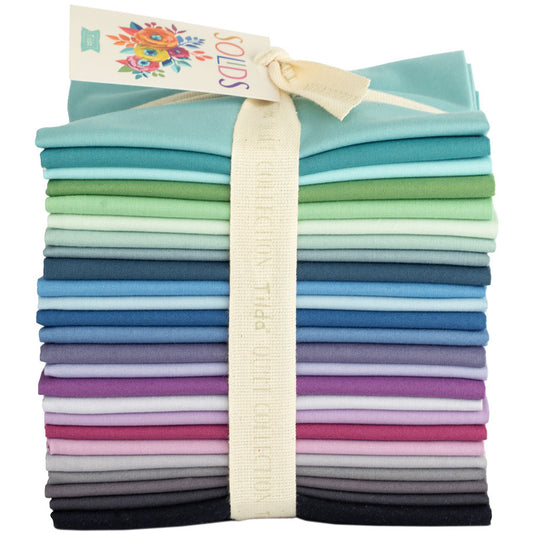 A bundle of pre-cut fat quarter pieces of fabric in various cool colors, tied together with a fabric ribbon.
Photo by Tildafabrics.com [image_link]