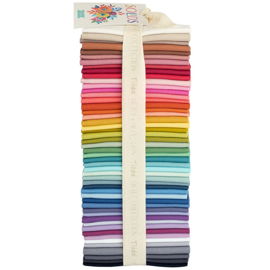 A bundle of Tilda Basics solid fat eighths fabrics in various colors, tied together with a label.
Photo by Tildafabrics.com [image_link]