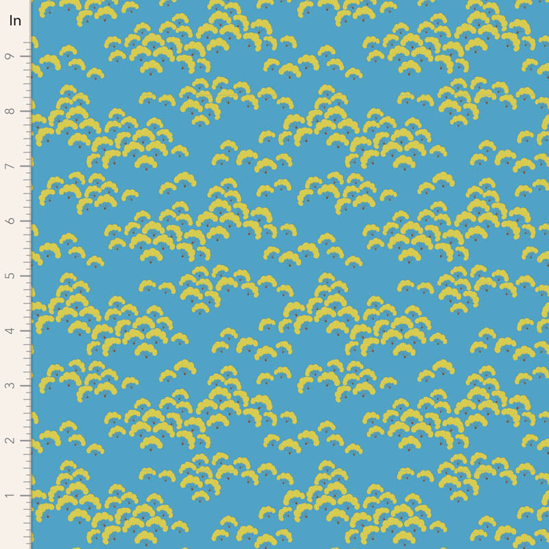 Fabric with yellow leaf pattern on a blue background, measured against a ruler.
Photo by Tildafabrics.com [image_link]