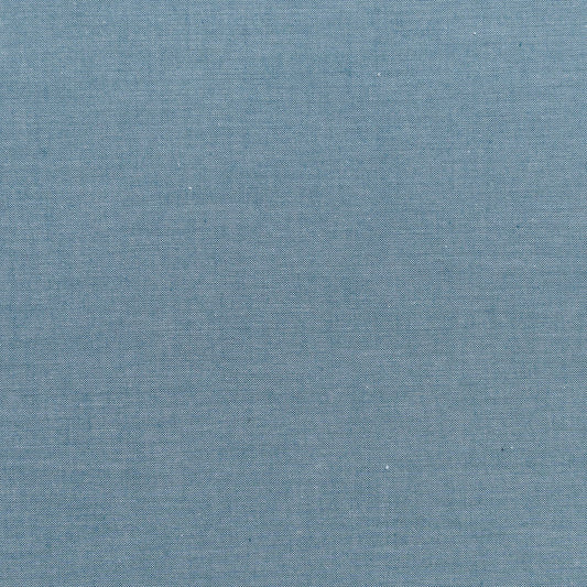 A swatch of Chambray Basics Petrol fabric from the Tilda Fabrics collection, displaying a woven blue fabric texture.
Photo by Tildafabrics.com [image_link]