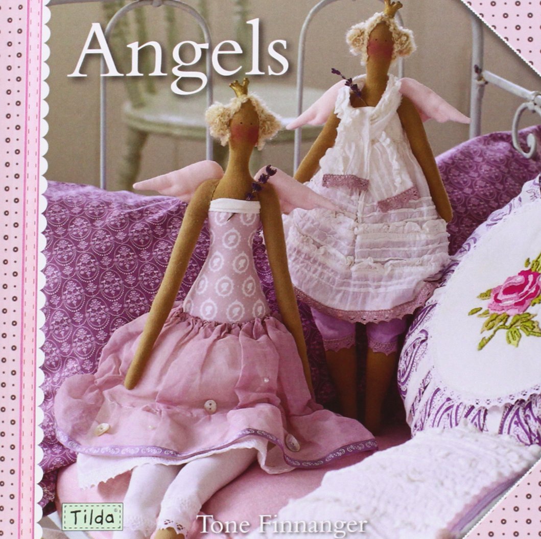 A book cover titled "Angels" by Tone Finnanger, featuring two fabric angel dolls in pink and white dresses posed on a bed with purple bedding.
Photo by Tildafabrics.com [additional_image_link]