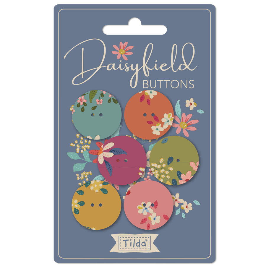 Daisyfield Buttons by Tilda, featuring six decorative buttons in muted floral colors on a slate blue backing card.
Photo by Tildafabrics.com [image_link]