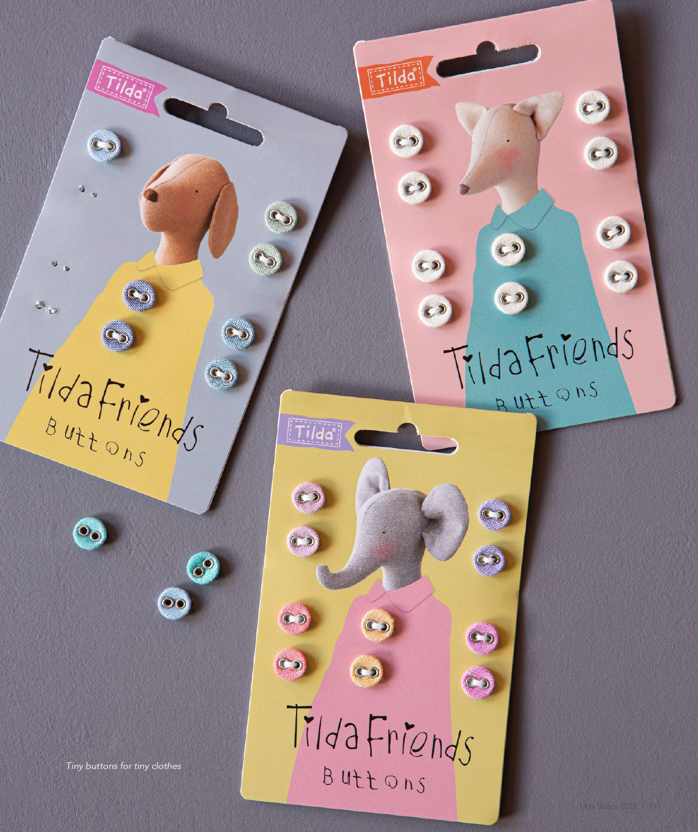 Three Tilda Friends buttons cards displaying assorted round buttons with animal illustrations, arranged on a gray surface.
Photo by Tildafabrics.com [additional_image_link]
