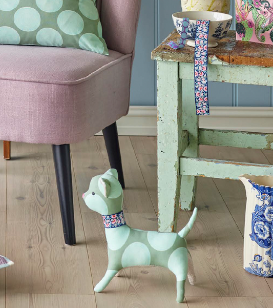 A sewing kit for creating a playful kitten doll, with a green and white color scheme, including various textiles and a pattern.
Photo by Tildafabrics.com [image_link]