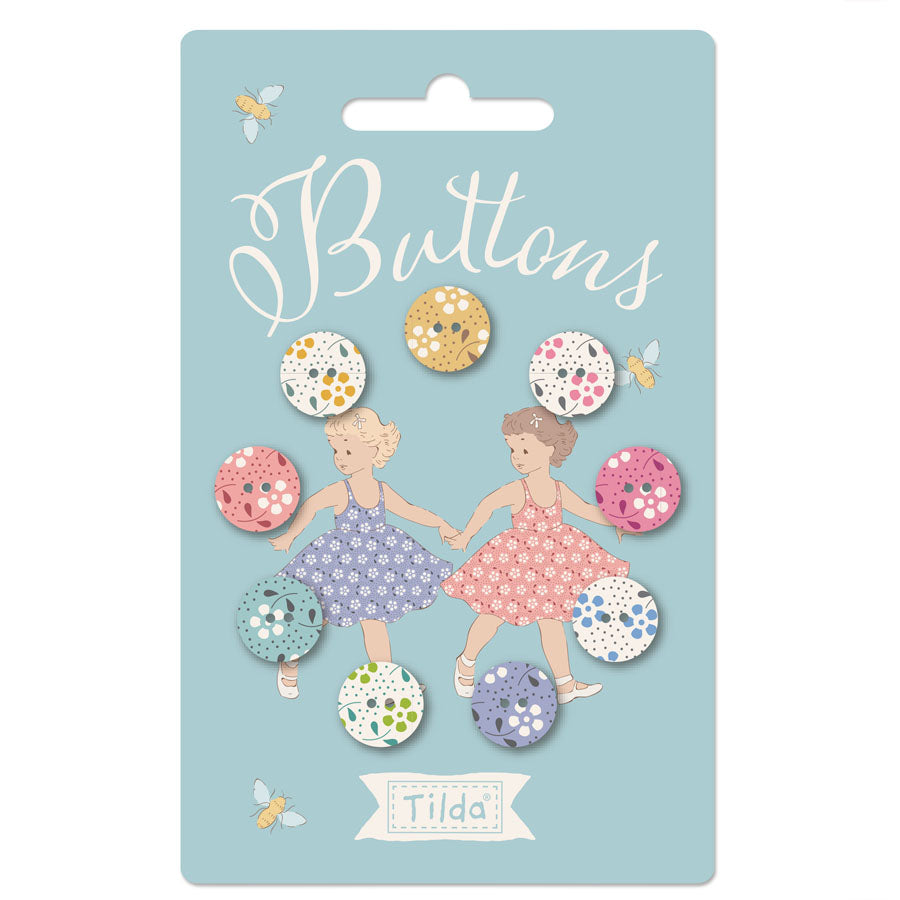 Packaging of Tilda Meadow Basics Buttons featuring floral patterned buttons and illustrations of two girls on the card.
Photo by Tildafabrics.com [image_link]
