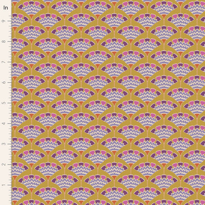 A close-up of a repeating fabric or wallpaper pattern with a mustard yellow background, scalloped fan motifs in pink, purple, and white, and a white ruler along the left edge marked in inches.
Photo by Tildafabrics.com [image_link]