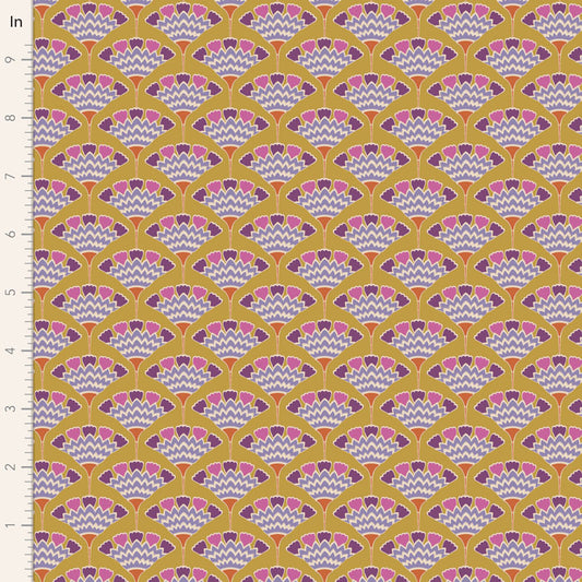A close-up of a repeating fabric or wallpaper pattern with a mustard yellow background, scalloped fan motifs in pink, purple, and white, and a white ruler along the left edge marked in inches.
Photo by Tildafabrics.com [image_link]