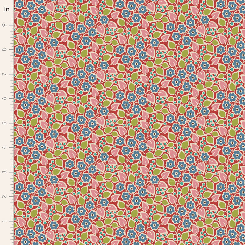 A close-up of a repeating floral patterned fabric or wallpaper sample with a ruler scale on the left edge. The pattern features pink flowers with blue centers and green leaves on a coral-red background.
Photo by Tildafabrics.com [image_link]