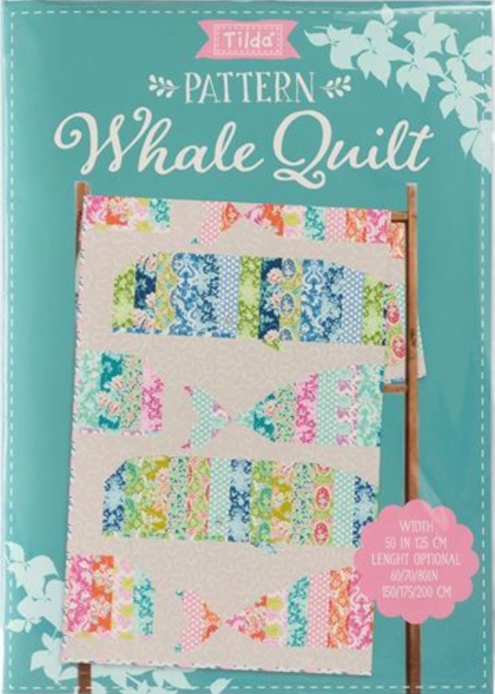 Tilda Tilda 'Pattern Whale Quilt' book cover, featuring a colorful patchwork whale quilt design on a light beige background, set against a teal cover with white floral accents.
Photo by Tildafabrics.com [additional_image_link]