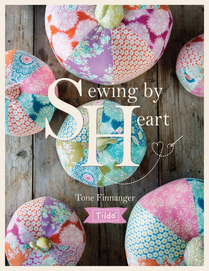 Cover of 'Sewing by Heart' with colorful fabric hearts on a wooden background
Photo by Tildafabrics.com [image_link]