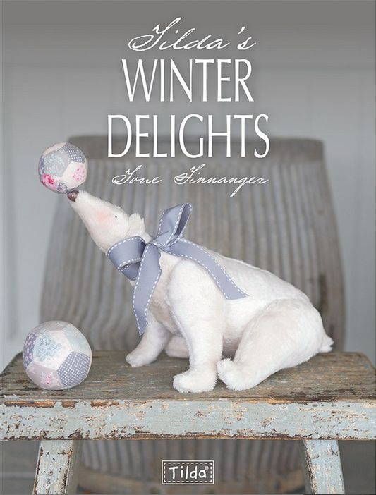 Front cover of Tilda's Winter Delights by Tone Finnanger. There is a polar bear  sitting on a wood stool balancing a ball on it's nose and a larger ball at it's feet.
Photo by Tildafabrics.com [image_link]