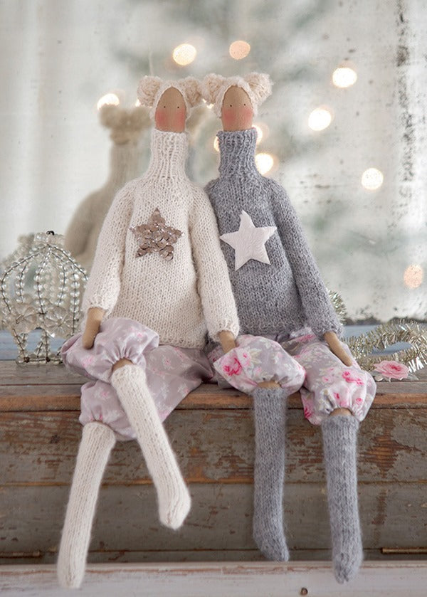 Two Tilda handmade dolls dressed for winter in knit sweaters with stars on them, knit stockings, bloomers and hairdos with two buns on each side.
Photo by Tildafabrics.com [additional_image_link]