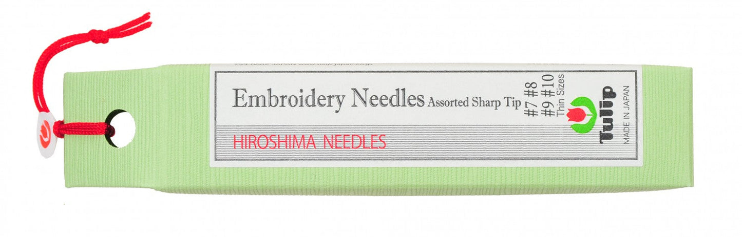A light green spool of Hiroshima needles with a red hanging cord and a white label that reads 'Embroidery Needles Assorted Sharp Tip' and 'HIROSHIMA NEEDLES'.
Photo by Tulip [image_link]