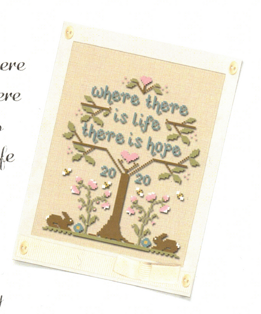 A cross stitch kit depicting a tree with heart shapes and the phrase 'WHERE THERE IS LIFE THERE IS HOPE' on a light background.
Photo by Country Cottage Needleworks [image_link]