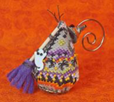 A small decorative witch-themed mouse ornament with a patterned body, purple tassel, white ghost detail, and a metal spiral loop, shown on an orange textured background.
Photo by JustNan.com [additional_image_link]