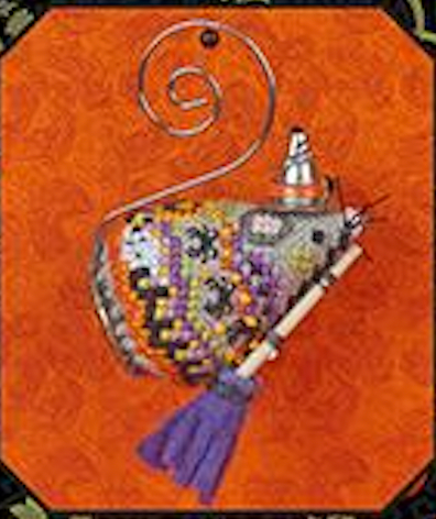 A decorative hanging ornament shaped like a stylized mouse wearing a small hat, with a purple tassel and a spiral metal wire hanger, shown against an orange patterned background.
Photo by JustNan.com [additional_image_link]